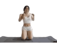 Woman Kneeling on Yoga Mat with Hands Up