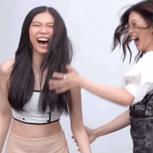 Woman Laughing As Another Holds Arm GIF
