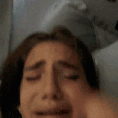 Woman Laying in Bed With Hand on Head
