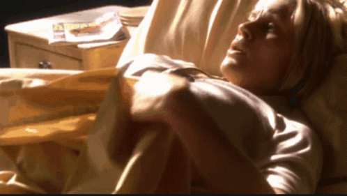 Woman Laying in Bed With Magazine on Nightstand