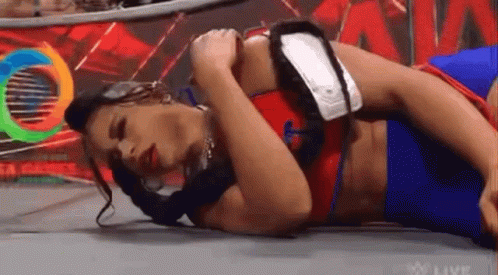 Woman Laying in Wrestling Ring Holding Arm