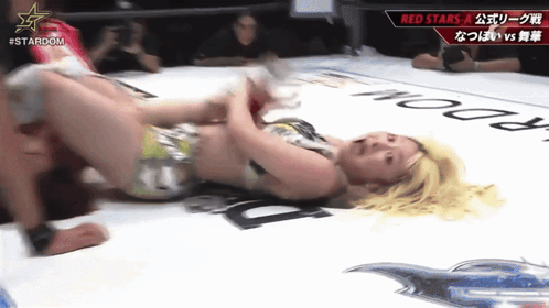 Woman Laying in Wrestling Ring with Stardom Logo