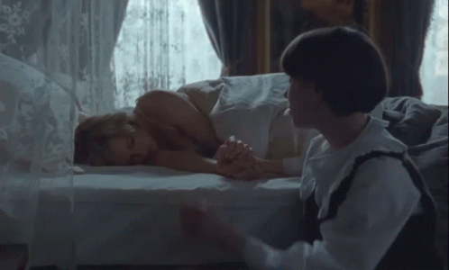 Woman Laying on Bed Man Holding Hand