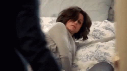 Woman Laying on Bed With Man Behind