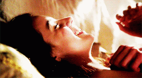 Woman Laying On Bed With Man Holding Her Neck GIF