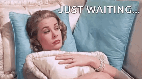 Woman Laying on Bed With Ring Saying Just Waiting