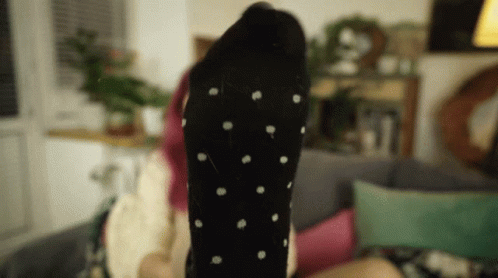 Woman Laying on Couch Feet Up Black Polka Dot Socks