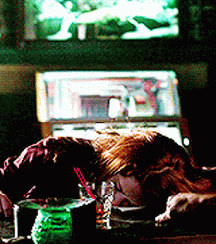 Woman Laying on Table With Drink in Front of Jukebox