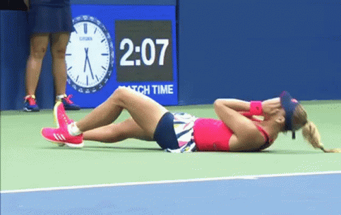 Woman Laying on Tennis Court With Clock 2:07