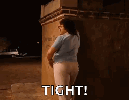 Woman Leaning Against Brick Wall at Night