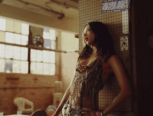 Woman Leaning Against Wall With Nicen Juicy Sign GIF