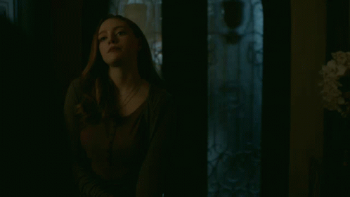 Woman Looking At Camera In Dark Room GIF