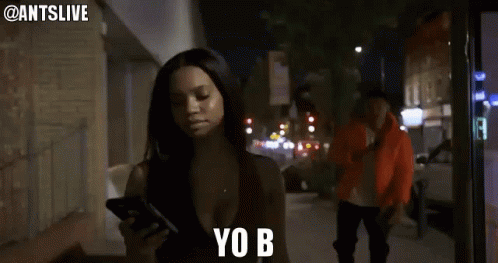 Woman Looking at Cell Phone Says Yo B