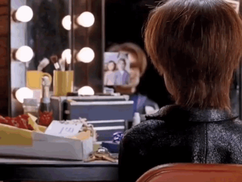 Woman Looking at Herself in Dressing Room Mirror