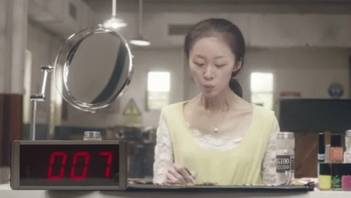 Woman Looking At Mirror With 007 Clock GIF