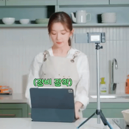 Woman Looking at Tablet on Tripod in Kitchen
