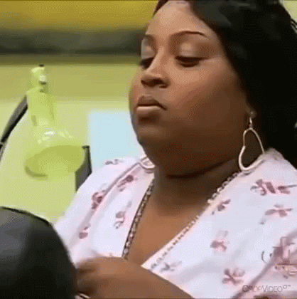 Woman Looking in Mirror Wearing Earrings