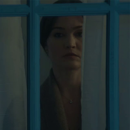 Woman Looking Out Blue Window