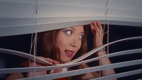 Woman Looking Through Window Blind Mouth Open