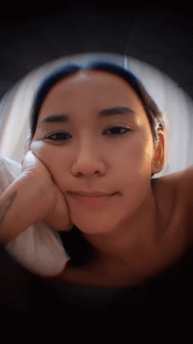 Woman Lying Down With Hand on Face