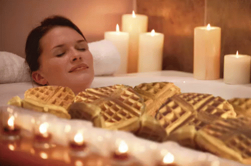Woman Lying In Bathtub Surrounded By Candles GIF
