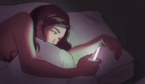 Woman Lying in Bed Looking at Cell Phone