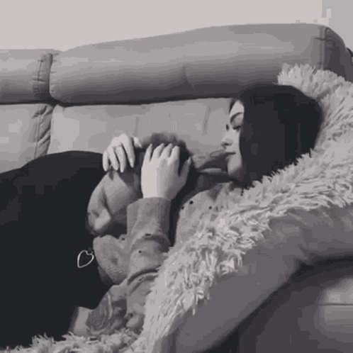 Woman Lying on Couch Holding Dog