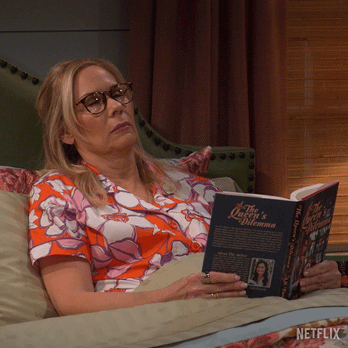 Woman Lying On Couch Reading Queen's Dilemma GIF