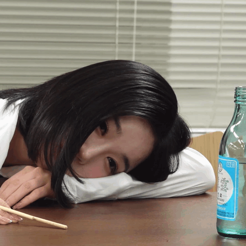 Woman Lying on Pillow Next to Soda Bottle