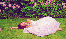 Woman Lying On The Grass With Flowers GIF