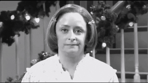 Woman Making Funny Face In Front Of Christmas Tree GIF