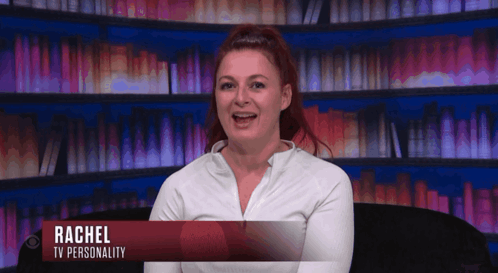 Woman Named Rachel Sits in Front of Bookshelf