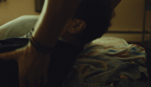 Woman Next to Man on Bed with Love on Wall