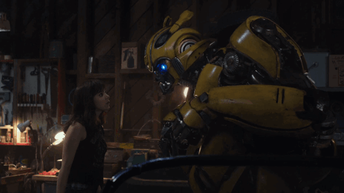 Woman Next to Yellow Robot in Dark Room