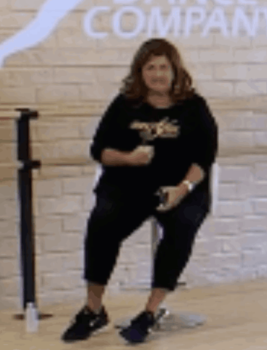Woman on Chair by Brick Wall with Company