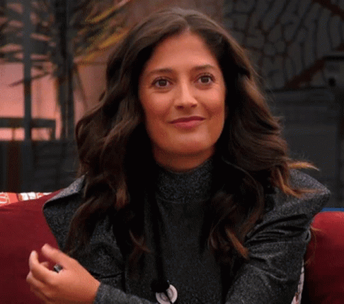 Woman On Couch Smiling Waving Hands GIF