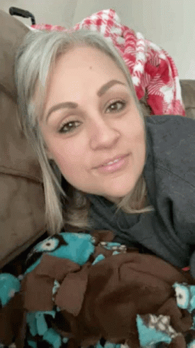 Woman on Couch with Blanket Smiling
