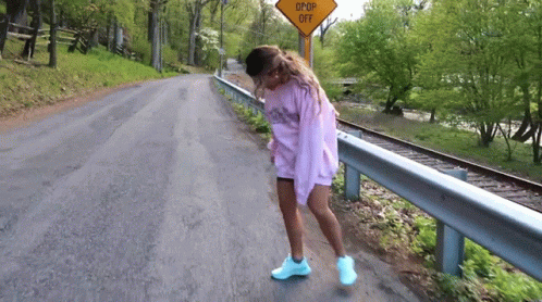 Woman On Road Near Drop Off Sign GIF