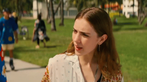 Woman on Sidewalk in Park With Man in Blue Shirt