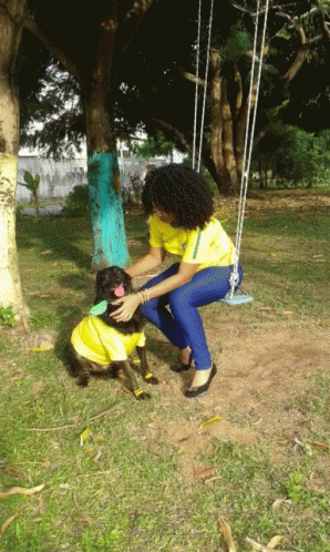 Woman on Swing Next to Dog in Yellow Shirt
