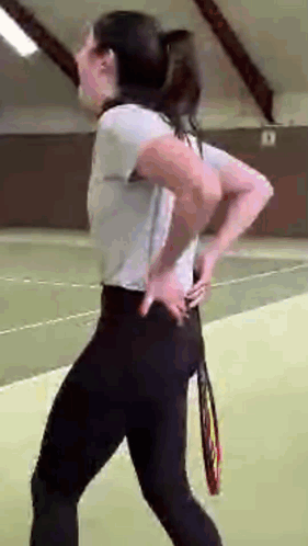 Woman On Tennis Court Holding Tennis Racquet GIF