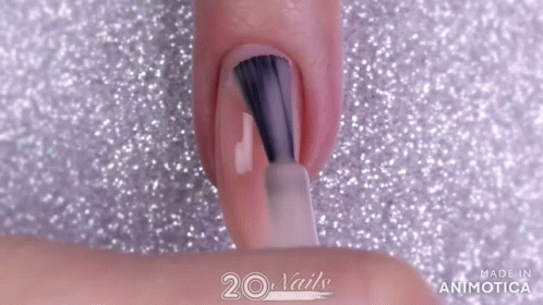 Woman Painting Nails with Brush on Glittery Surface