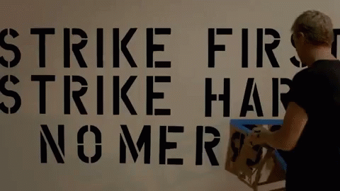 Woman Paints Strike First Strike Hard No Mercy GIF