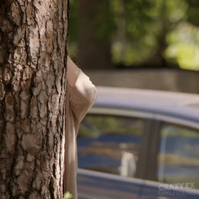 Woman Peeking Behind Tree