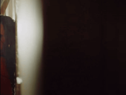 Woman Peeking From Behind Wall GIF