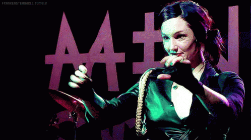 Woman Playing Drums In Front Of AA Sign GIF