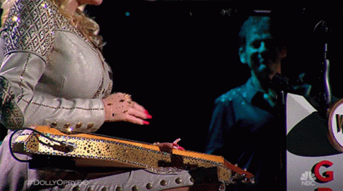 Woman Playing Guitar in Front of NBC Podium