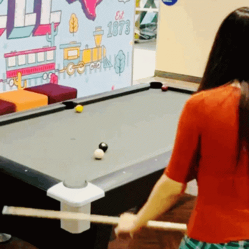 Woman Playing Pool in Front of Est 1973 Wall