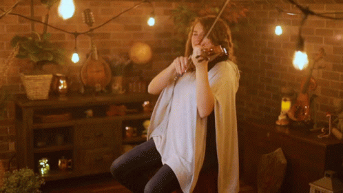 Woman Playing Violin With String Lights