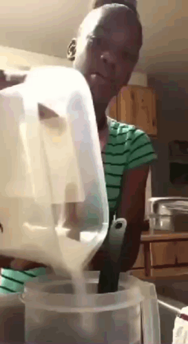 Woman Pouring Milk Into Plastic Container With Spoon GIF